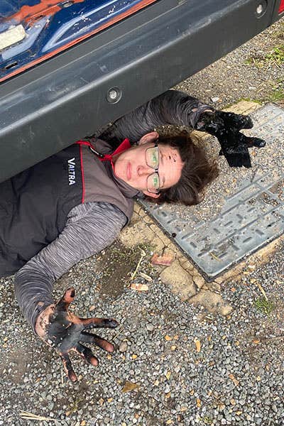 Maddy, appearing out from under the Mercedes Sprinter with oily hands
